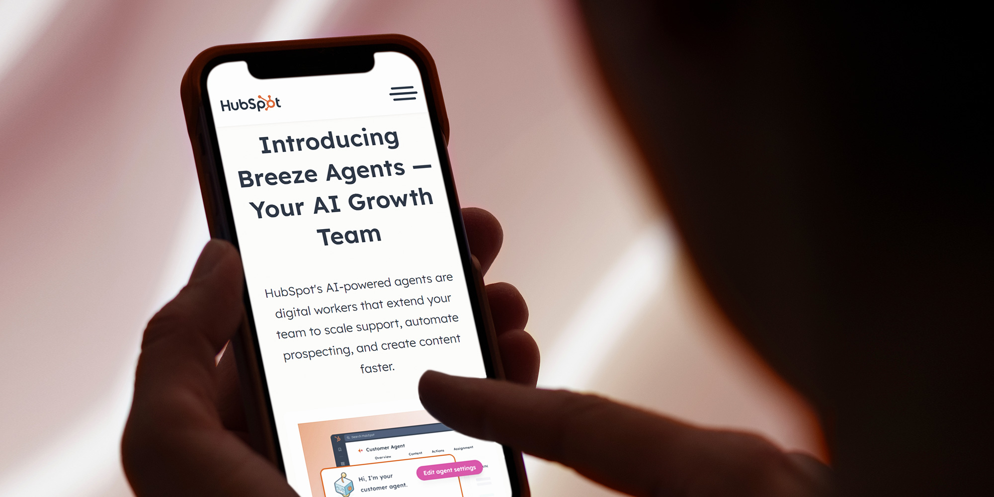 Image of phone with a HubSpot article pulled up about AI agents.