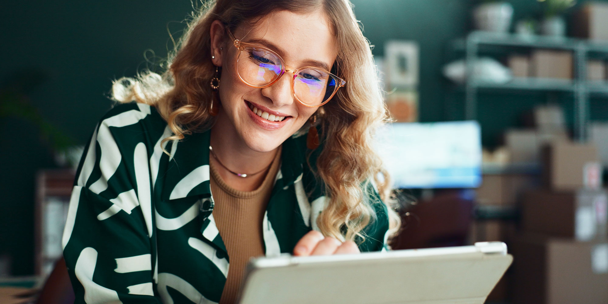 woman smiling looks at her laptop