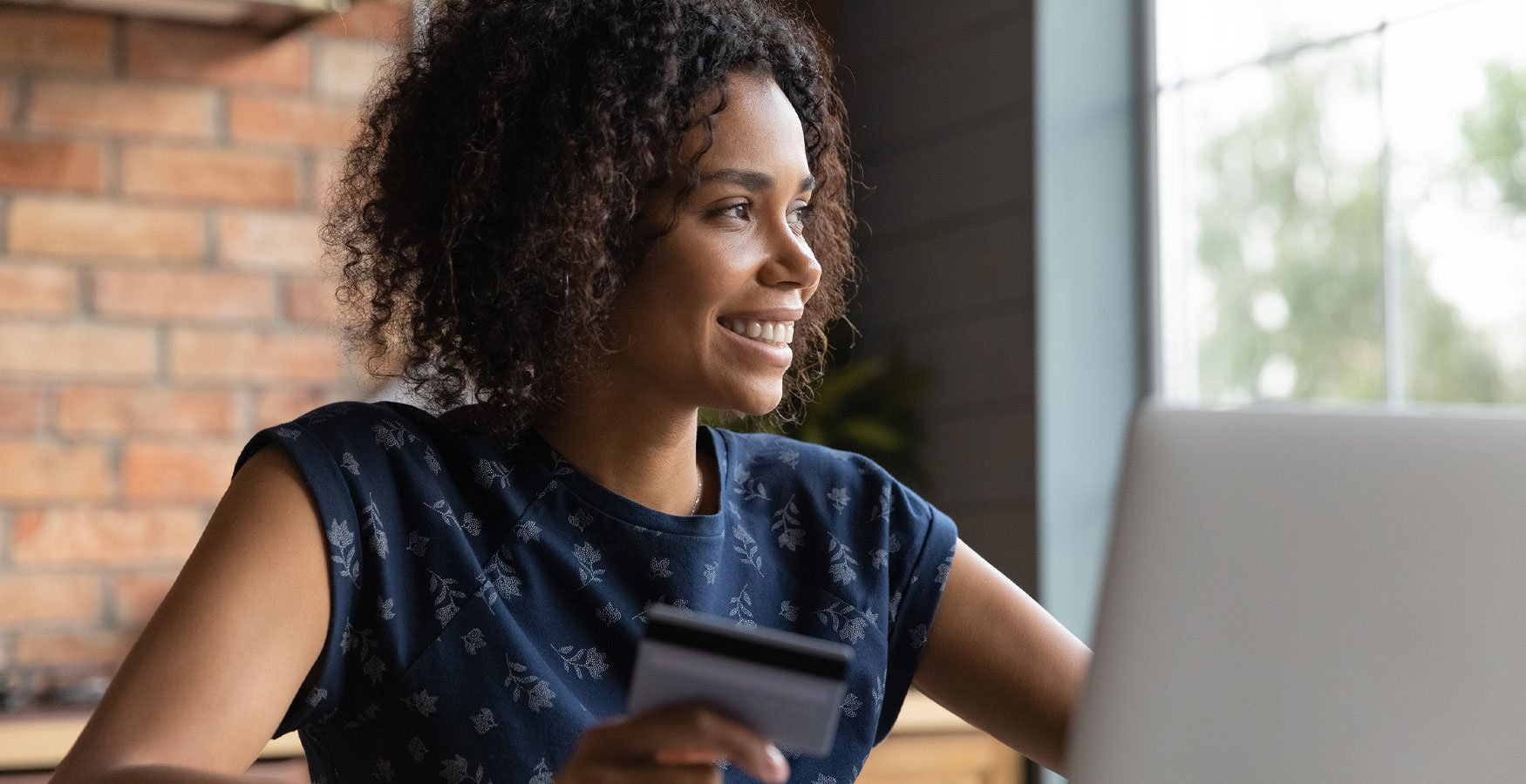 woman smiling holding a credit card